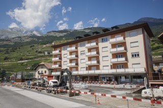 Le batiment suppose ou ont ete decouverts trois corps sans vie est photographie ce dimanche 28 juillet 2024 a Vetroz. Dimanche matin trois personnes ont ete decouvertes decedees dans deux appartements situes sur la commune de Vetroz a la suite d'une alerte a la police faisant suite a des coups de feu. (KEYSTONE/Valentin Flauraud)